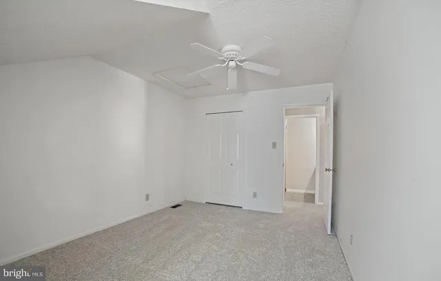 an empty room with a ceiling fan and a window