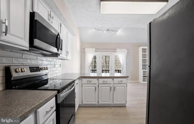 a kitchen with stainless steel appliances granite countertop a sink and a stove