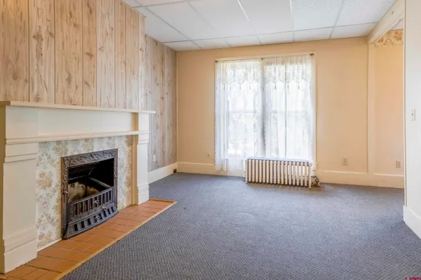 a view of an empty room with a fireplace and a window