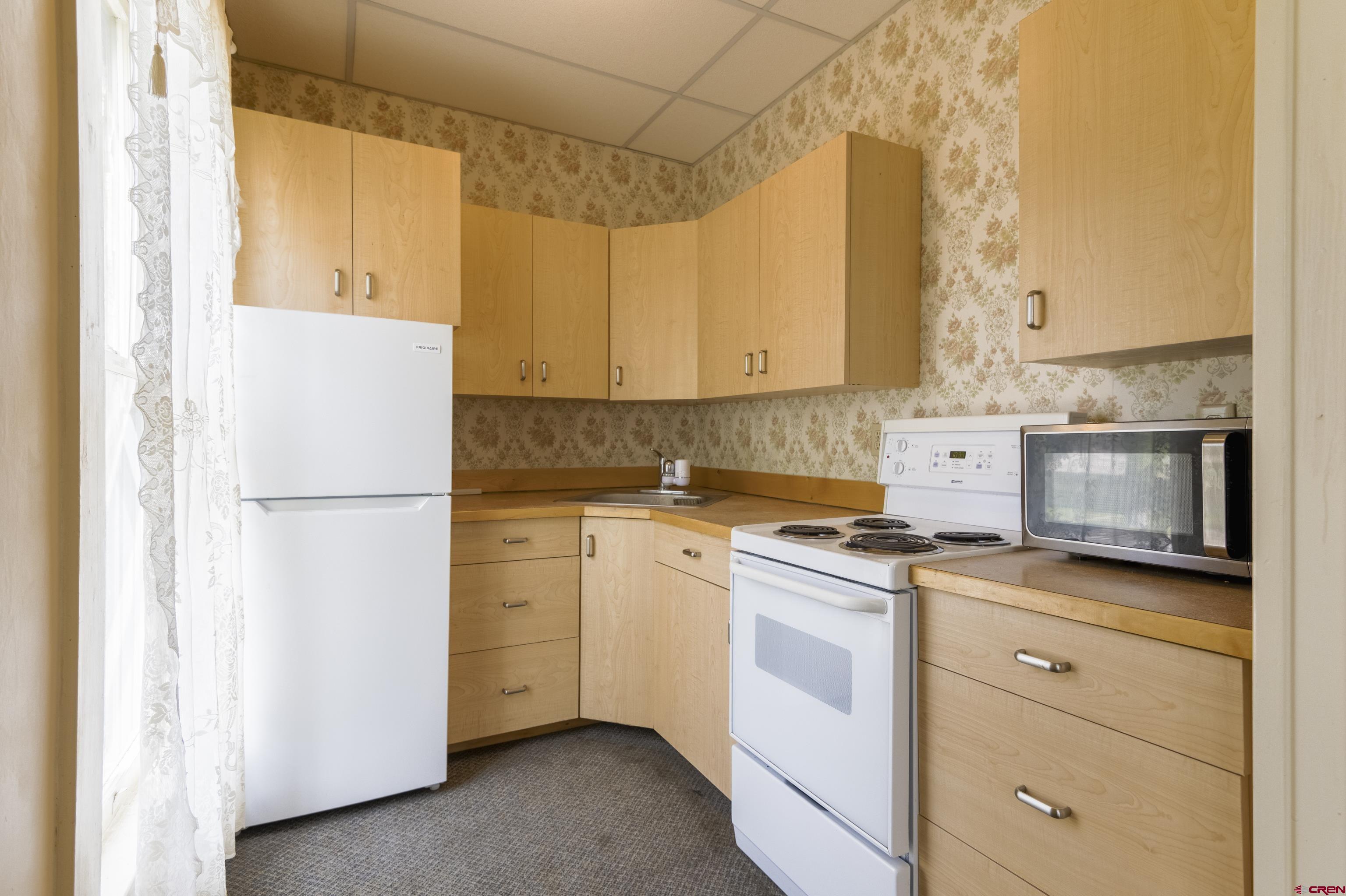 518 East Georgia Avenue Gunnison, CO 81230 - Photo 14 of 40 a kitchen with a stove a sink and a refrigerator