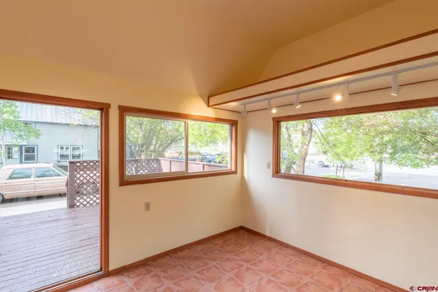 a view of empty room with window and wooden floor
