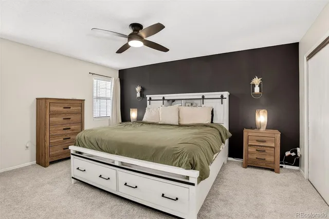 a spacious bedroom with a bed and a ceiling fan