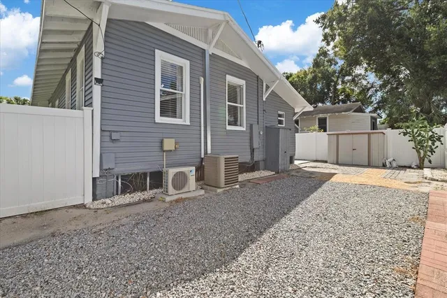 a view of a house with a yard and large tree