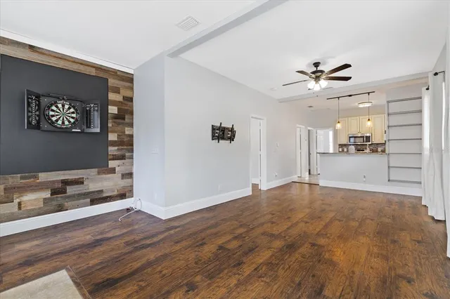 a view of empty room with wooden floor and ceiling fan