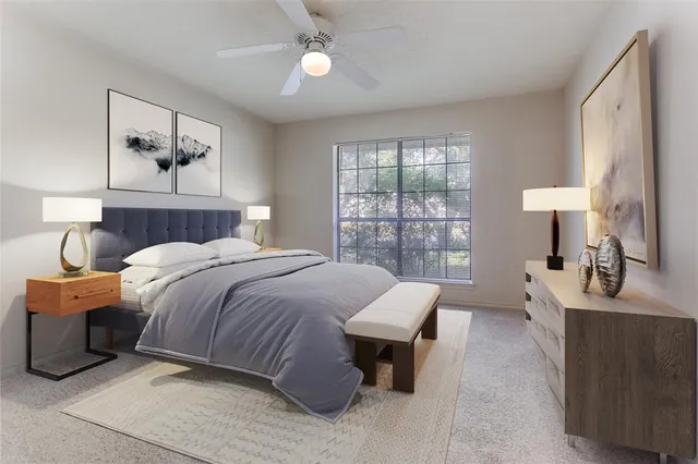 a bedroom with a bed a table and painting on the wall