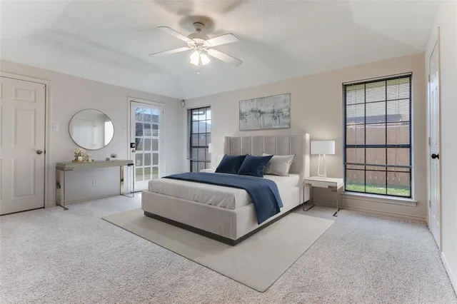 a spacious bedroom with a large bed a chandelier and windows