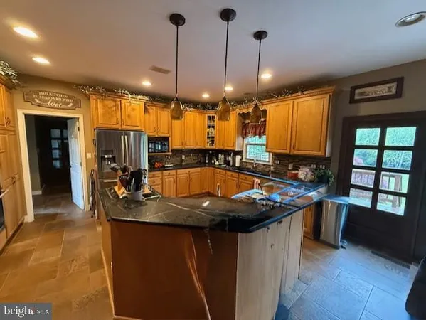 a kitchen with stainless steel appliances granite countertop a sink a stove and a wooden floors