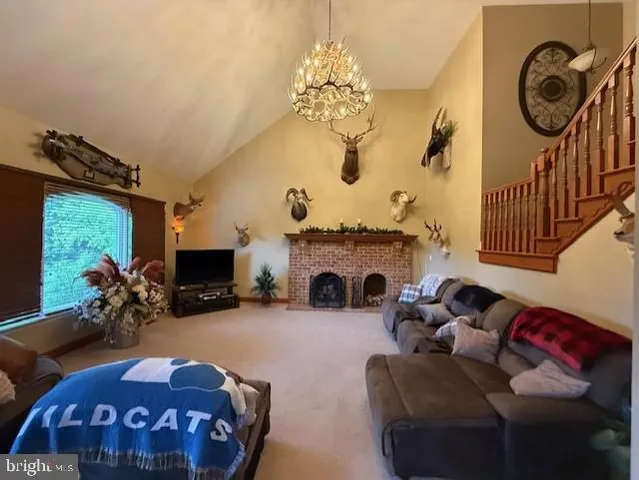 a living room with furniture a fireplace and a chandelier