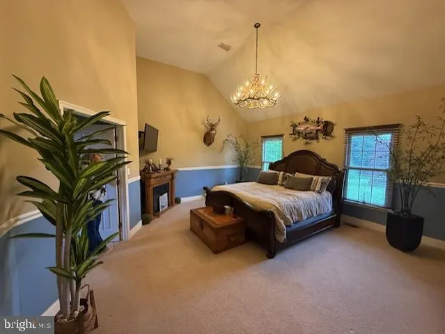 a bedroom with a large bed and a chandelier