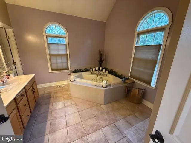 a bathroom with a tub sink and mirror