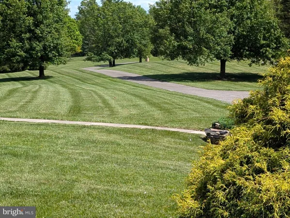a backyard of a house with lots of green space and fountain
