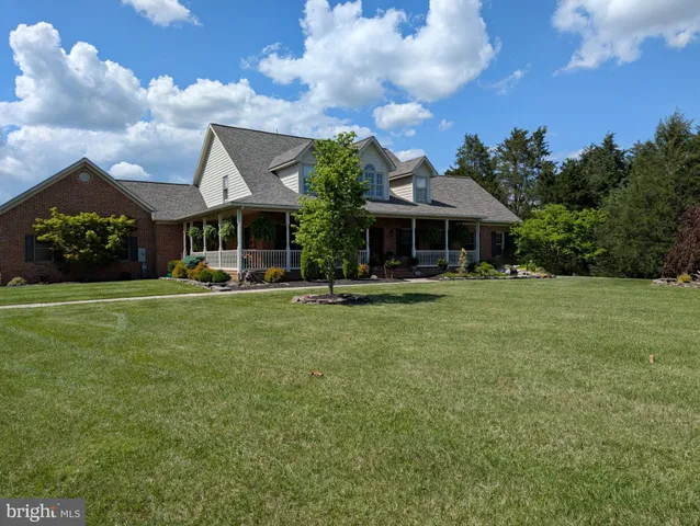 a front view of a house with garden and trees