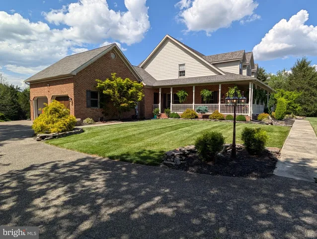 a front view of a house with a garden and trees