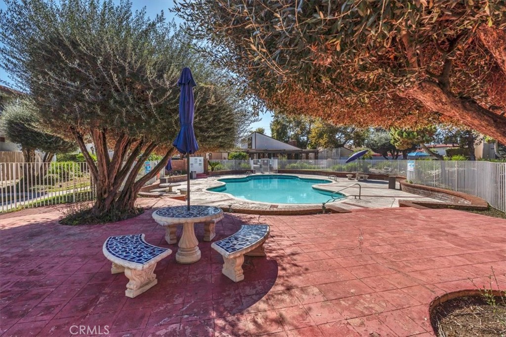 2521 West Sunflower Avenue, Unit H2 Santa Ana, CA 92704 - Photo 27 of 30 a view of a backyard with table and chairs potted plants and large tree
