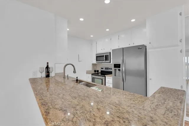 a kitchen with stainless steel appliances granite countertop a refrigerator a stove a sink a refrigerator and cabinets