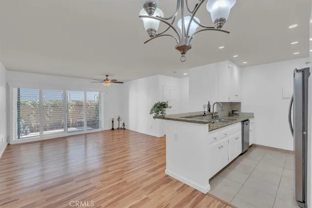 a large white kitchen with a large window appliances and cabinets