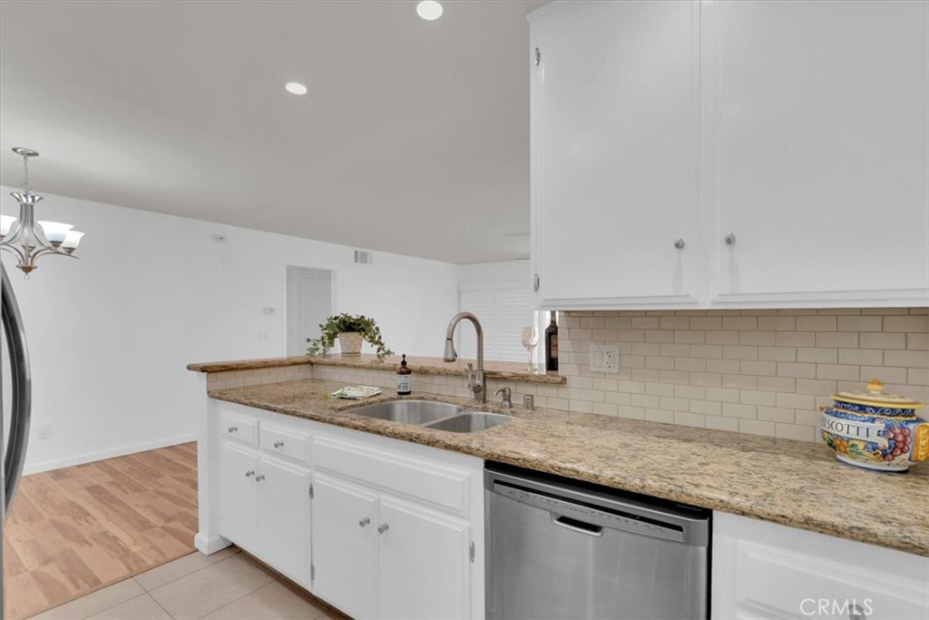 2521 West Sunflower Avenue, Unit H2 Santa Ana, CA 92704 - Photo 10 of 30 a kitchen with granite countertop white cabinets and a sink