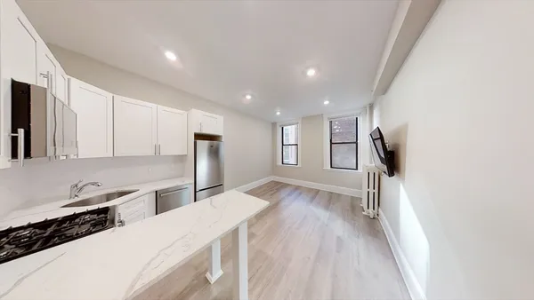 a kitchen with stainless steel appliances a refrigerator and a stove top oven