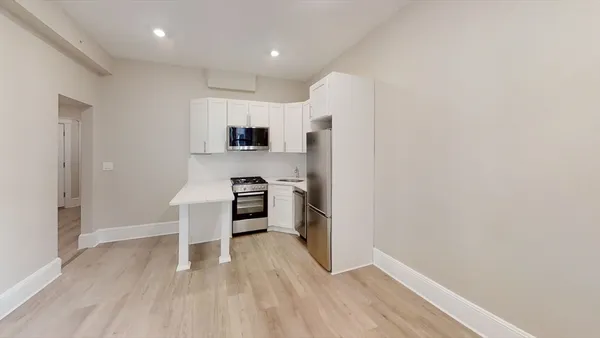 a view of kitchen with stainless steel appliances a refrigerator and a stove top oven