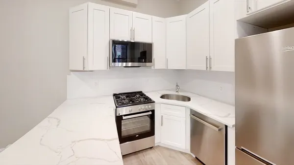 a kitchen with white cabinets and stainless steel appliances
