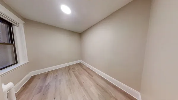 a view of empty room with wooden floor
