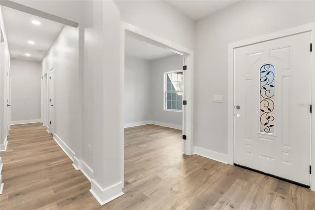 a view of a hallway with wooden floor and closet