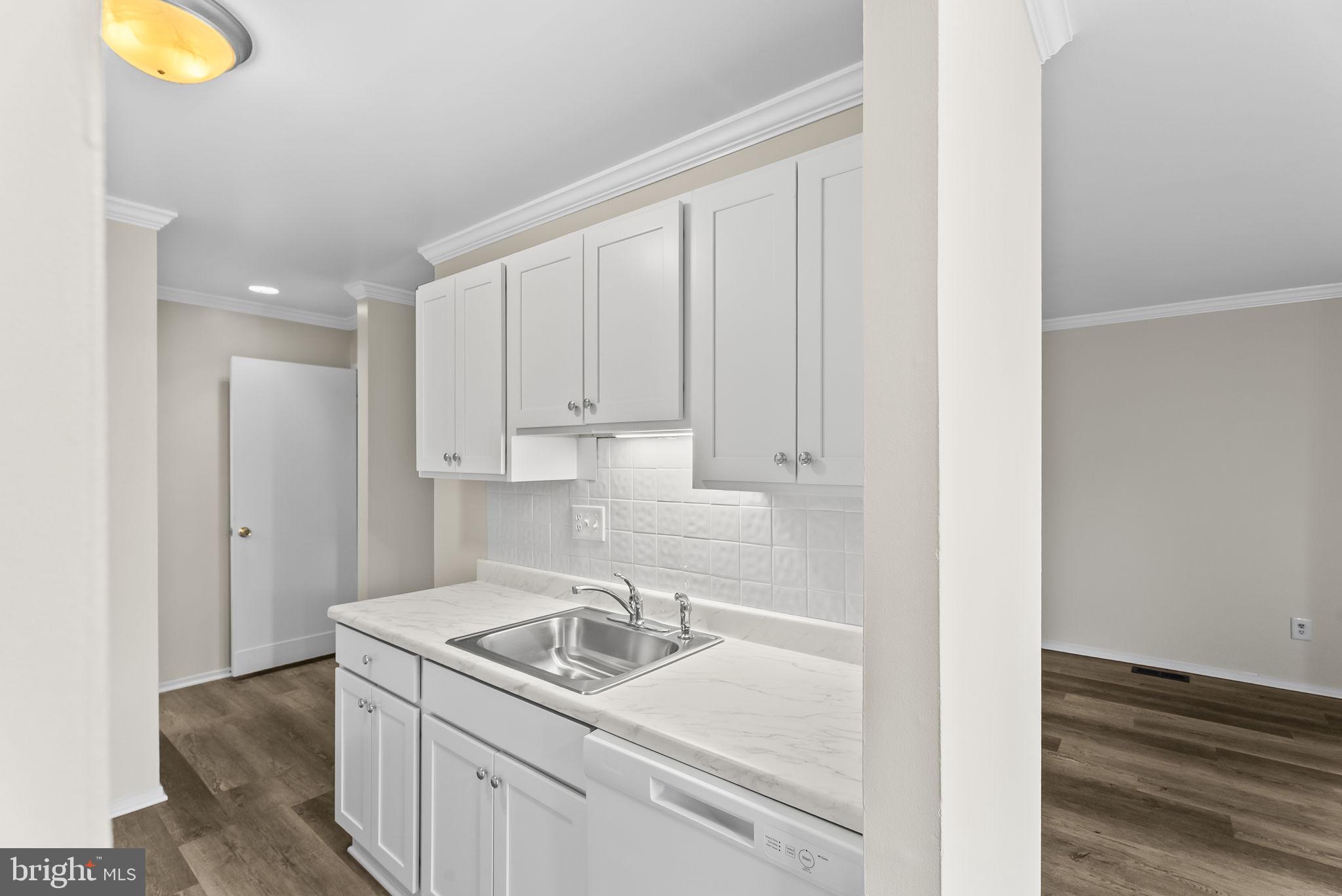 9413 Penshurst Court Gaithersburg, MD 20886 - Photo 14 of 32 a kitchen with a sink and cabinets