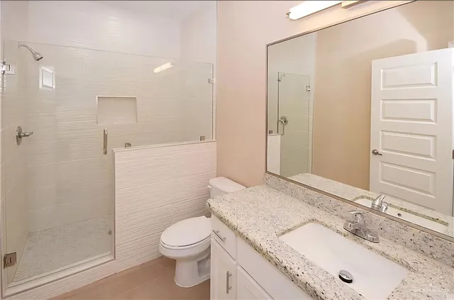 a kitchen with granite countertop white cabinets and white appliances