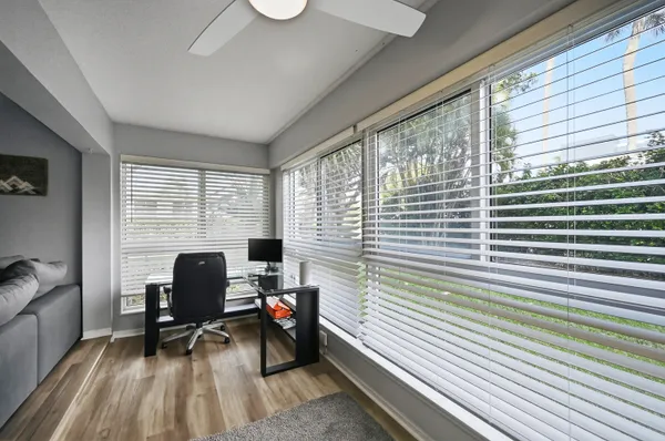 a view of a workspace with furniture and a window