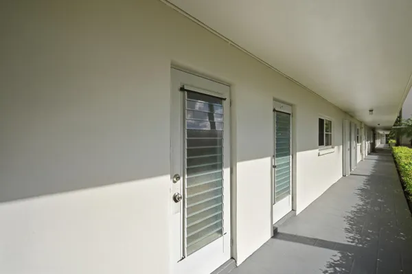 a view of a hallway with wooden floor and windows