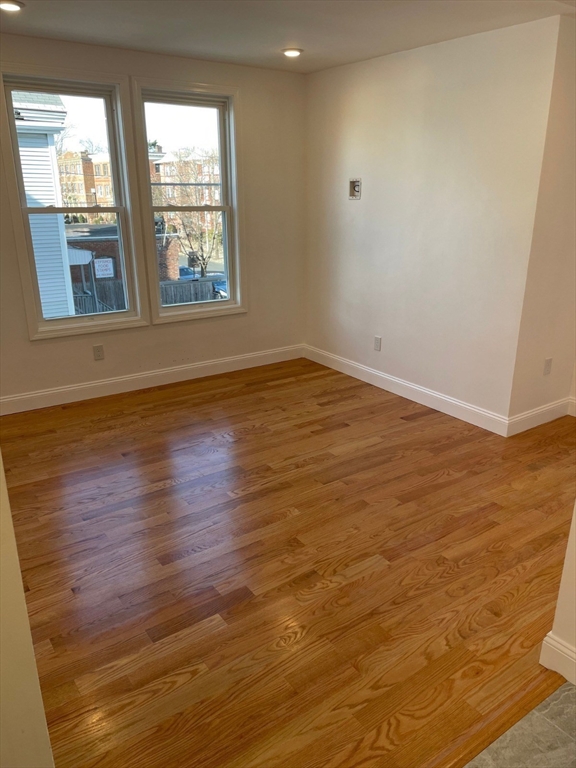 217 Washington Street, Unit 2L Lynn, MA 01902 - Photo 3 of 11 a view of an empty room with wooden floor and a window