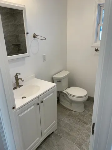 a bathroom with a toilet sink and mirror