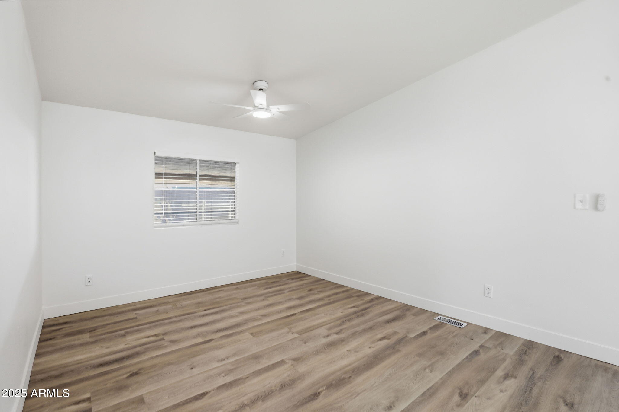 3500 South Tomahawk Road, Unit 142 Apache Junction, AZ 85119 - Photo 11 of 38 an empty room with wooden floor and windows