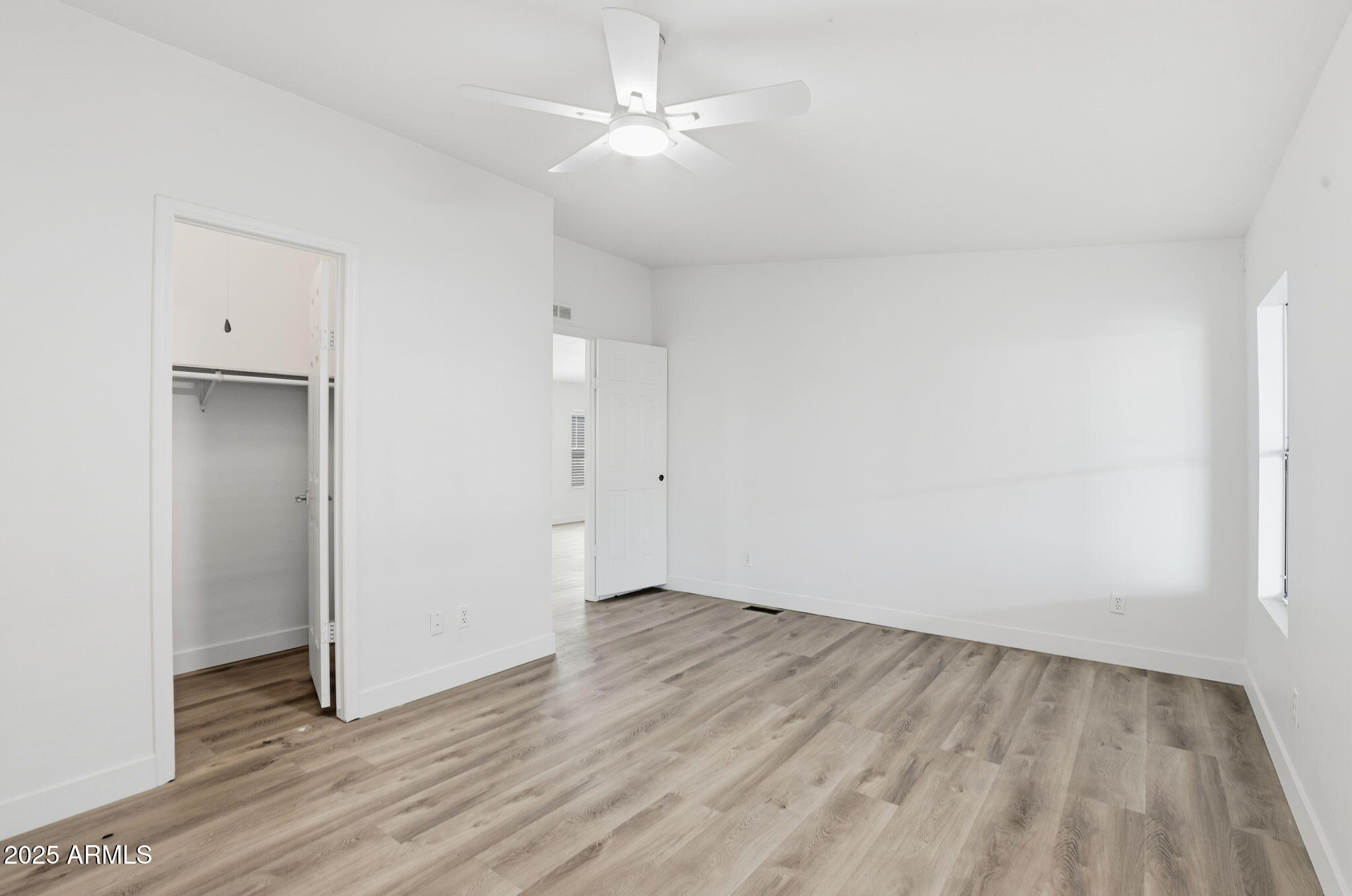 3500 South Tomahawk Road, Unit 142 Apache Junction, AZ 85119 - Photo 15 of 38 an empty room with wooden floor and windows
