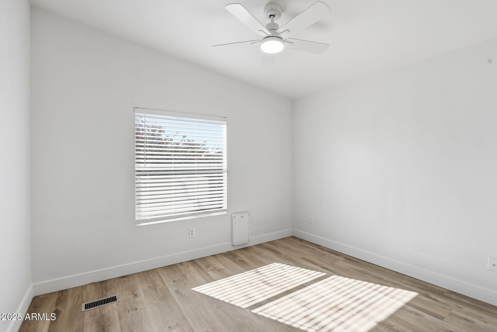 3500 South Tomahawk Road, Unit 142 Apache Junction, AZ 85119 - Photo 20 of 38 a view of an empty room with wooden floor and a window