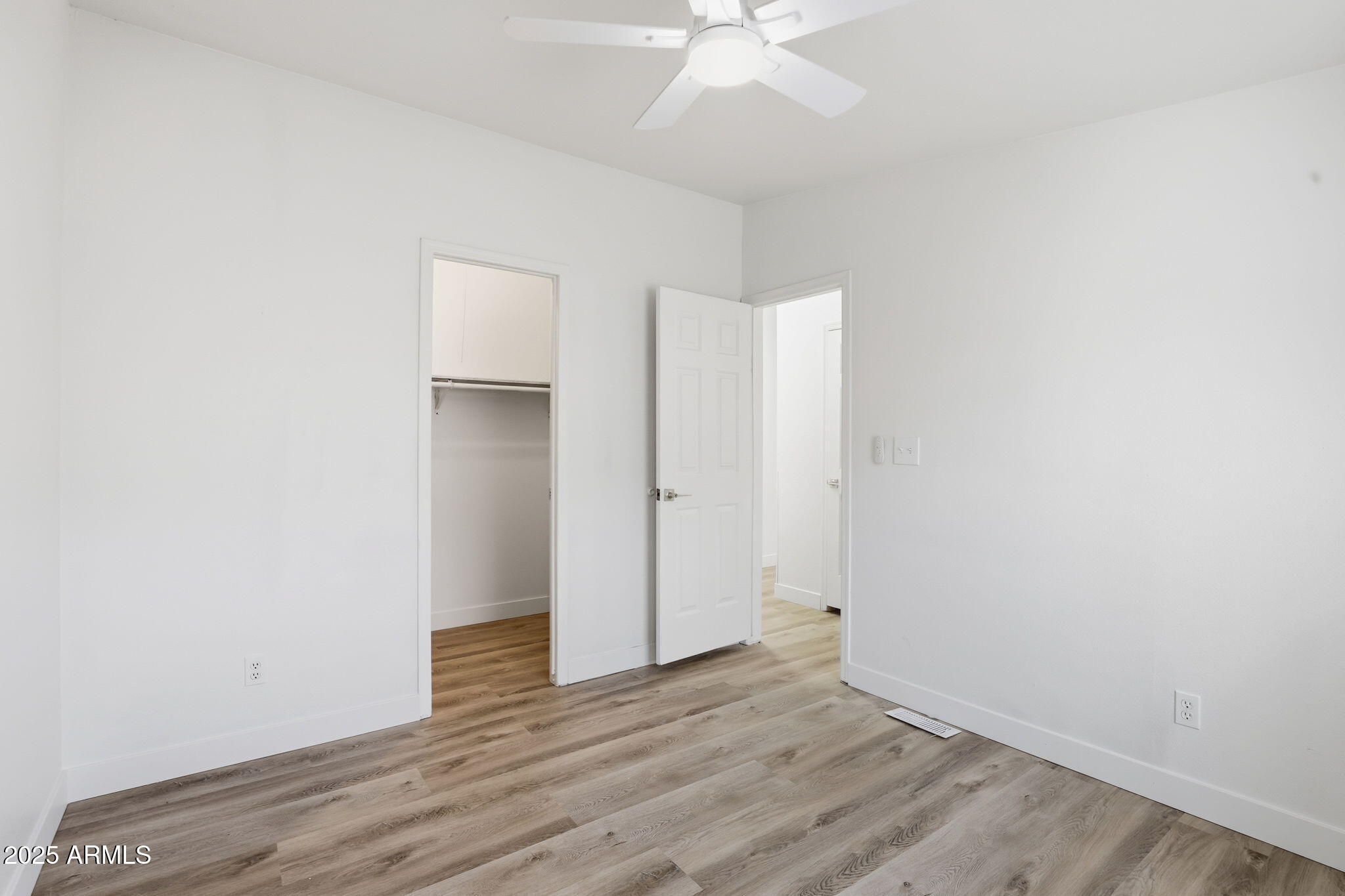 3500 South Tomahawk Road, Unit 142 Apache Junction, AZ 85119 - Photo 24 of 38 an empty room with wooden floor and hallway