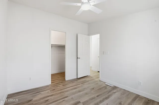 an empty room with wooden floor and hallway