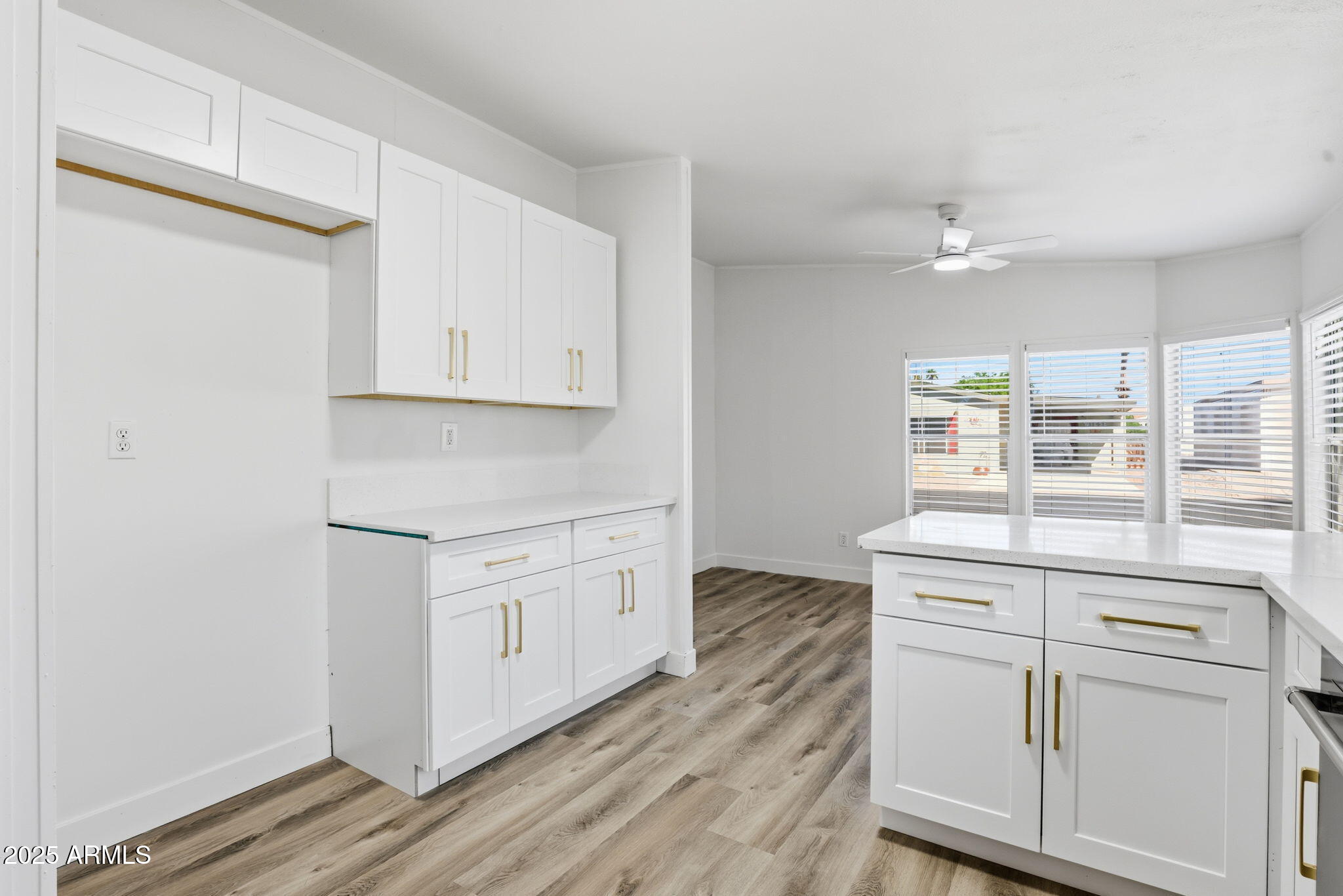 3500 South Tomahawk Road, Unit 142 Apache Junction, AZ 85119 - Photo 7 of 38 a kitchen with stainless steel appliances granite countertop a stove a sink and white cabinets with wooden floor