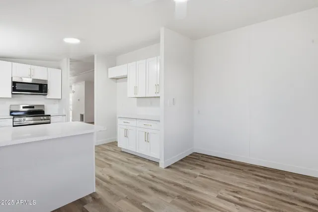 a kitchen with wooden floor and white appliances