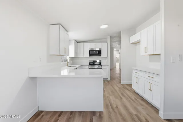 a kitchen with white cabinets and stainless steel appliances