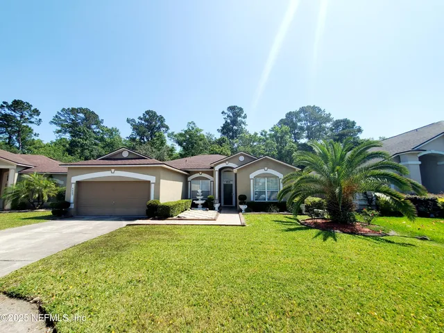 a front view of house with yard and green space