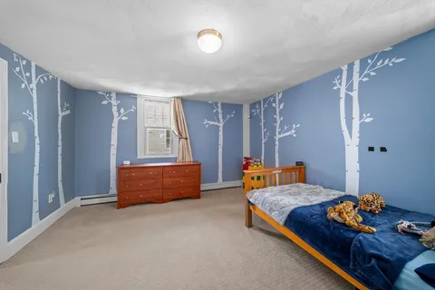 a blue bed sitting in a room next to a window