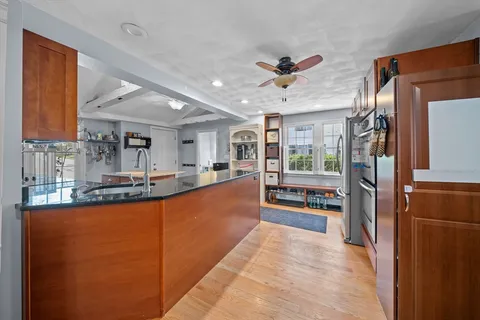 a large kitchen with stainless steel appliances granite countertop a refrigerator and a sink