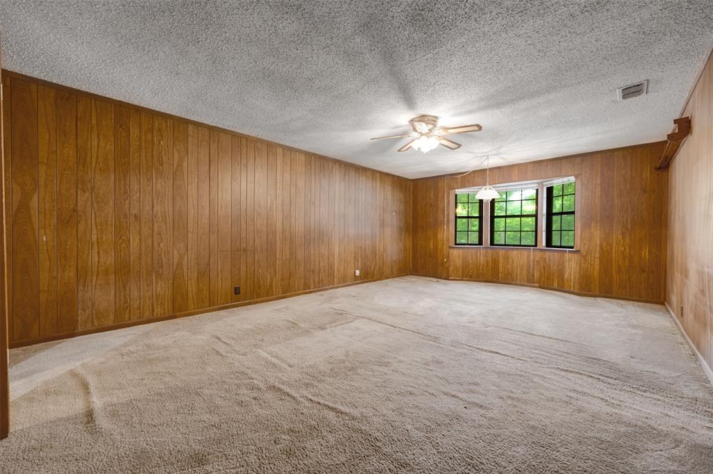 8798 Hill N Dale Road Tyler, TX 75709 - Photo 16 of 31 Spacious interior with full wood paneling and a textured ceiling
