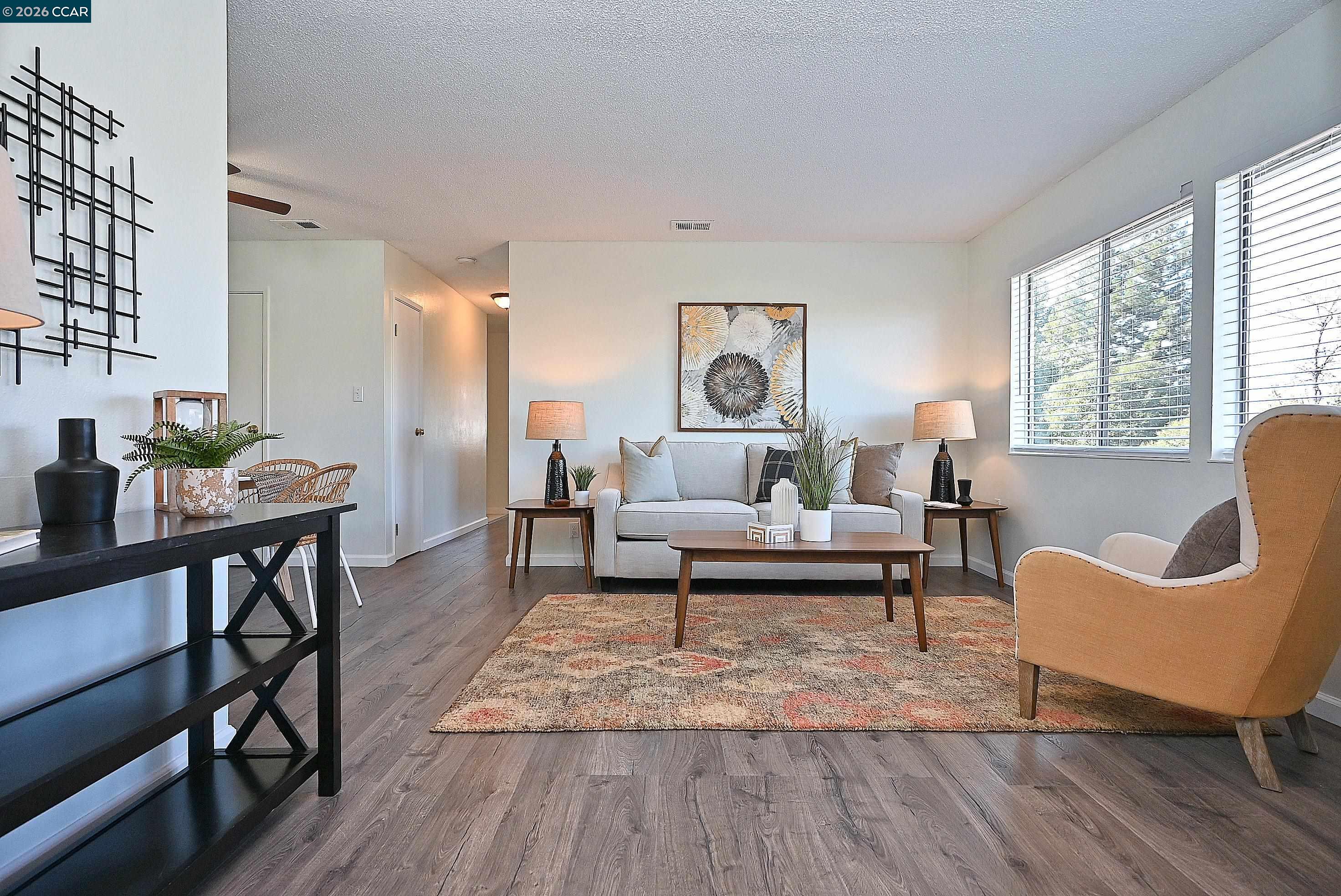 a living room with furniture and a wooden floor