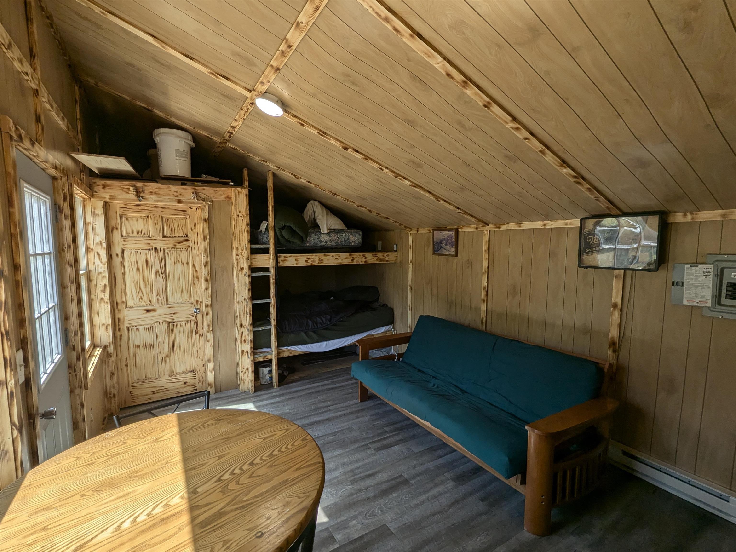 7163 W Highway 2 Hurley, WI 54534 - Photo 11 of 13 Sitting room featuring baseboard heating, vaulted ceiling, wood ceiling, and wooden walls