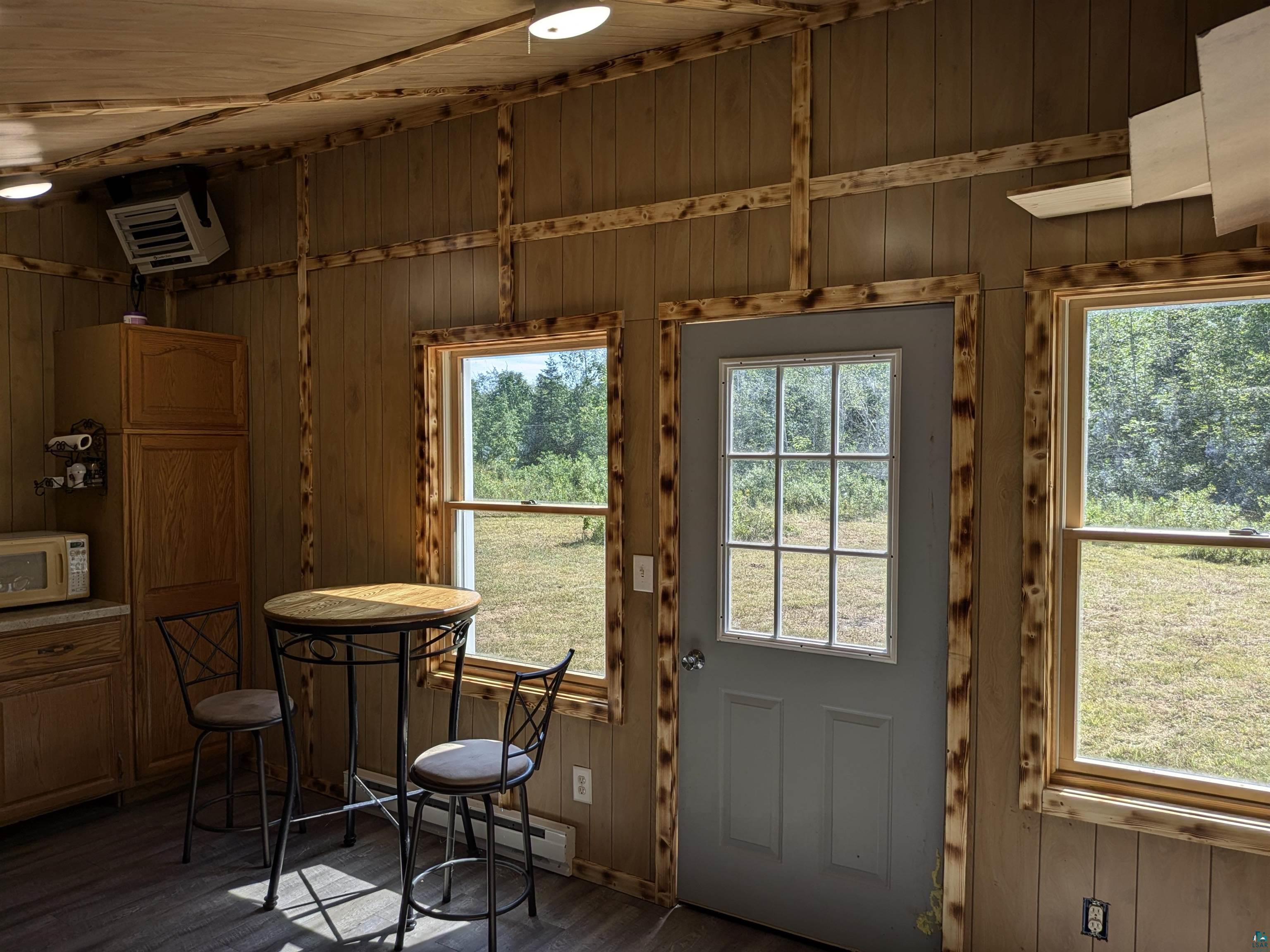 7163 W Highway 2 Hurley, WI 54534 - Photo 10 of 13 Doorway featuring a healthy amount of sunlight, a baseboard heating unit, and dark hardwood / wood-style floors