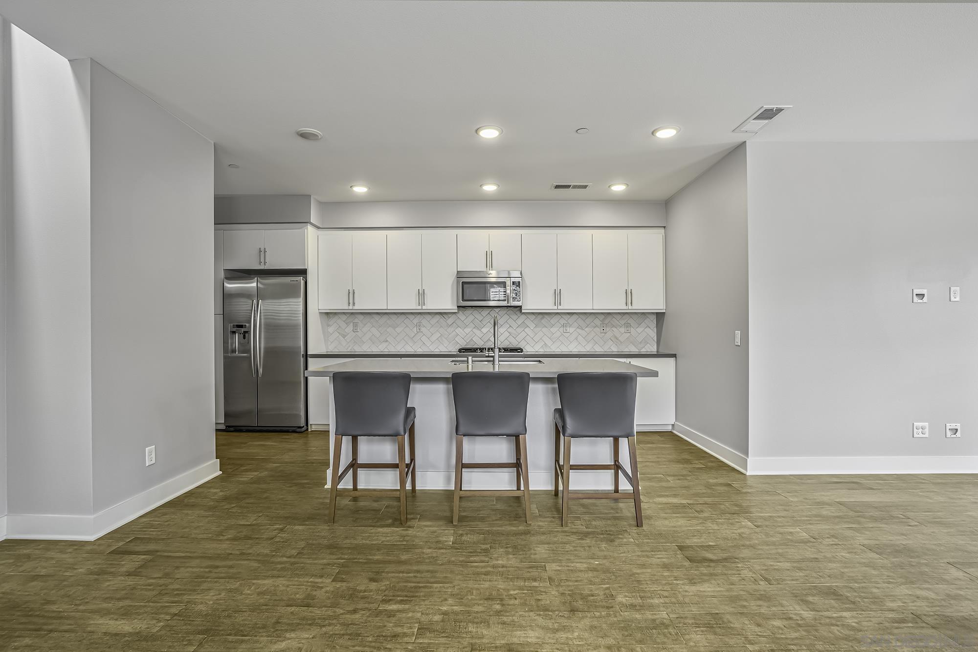 145 Stonesteps Way Encinitas, CA 92024 - Photo 2 of 25 a kitchen with kitchen island granite countertop a counter top space cabinets and stainless steel appliances