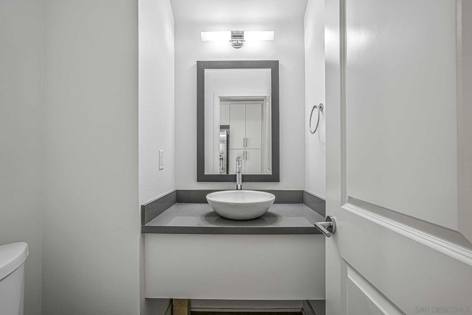 145 Stonesteps Way Encinitas, CA 92024 - Photo 6 of 25 a bathroom with a granite countertop sink and a mirror