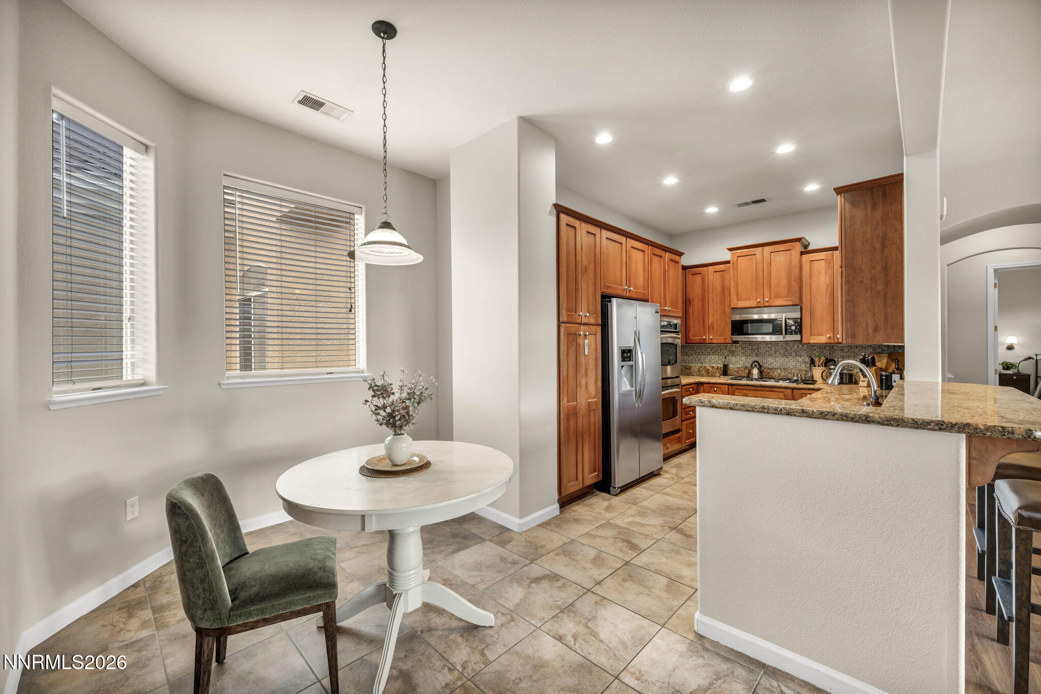 9900 Wilbur May Parkway, Unit 2405 Reno, NV 89521 - Photo 33 of 81 a kitchen with refrigerator a sink and chairs